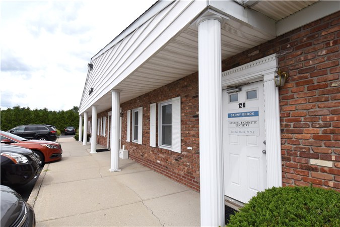 The entrance to Building 12D at Stony Brook Medical Park, a brick building with white columns and a walkway.