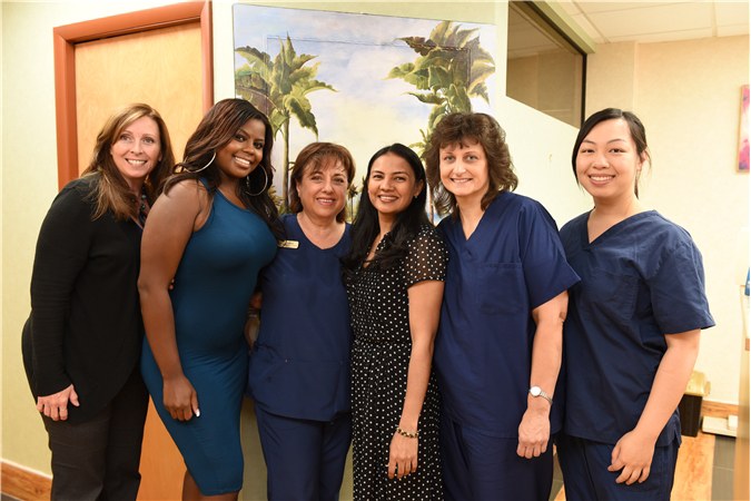 The full team at Stony Brook General & Cosmetic Dentistry standing together in the office.